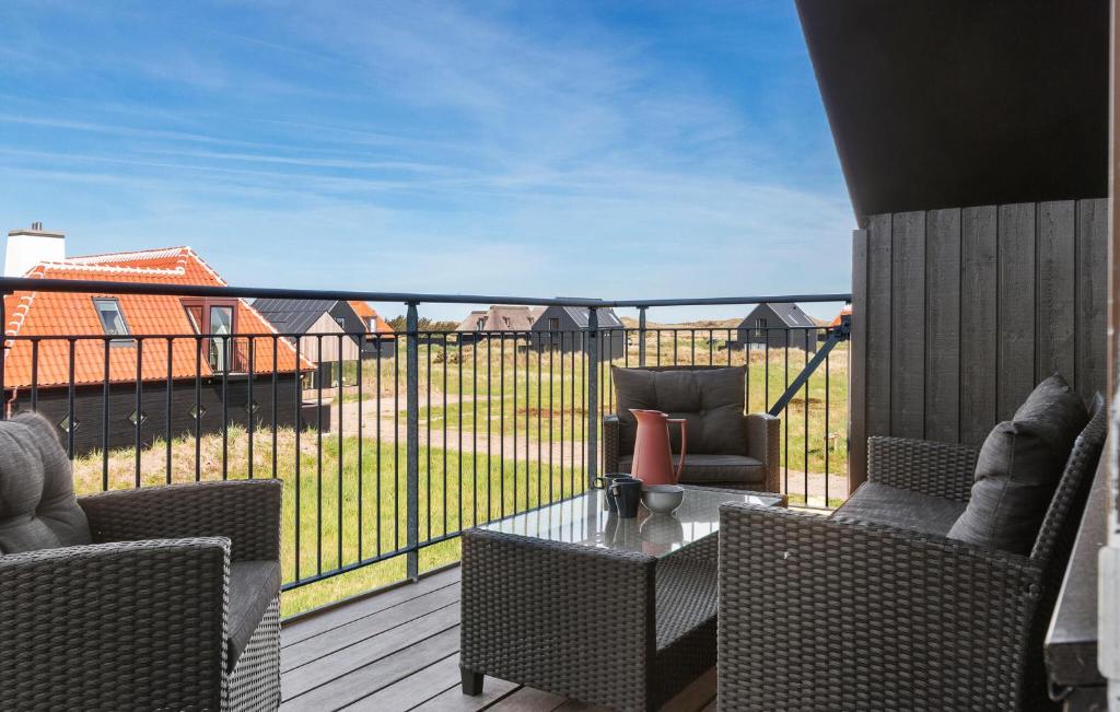 斯卡恩的住宿－Ocean Front Home In Skagen With Wifi，阳台配有两把椅子和一张桌子,甲板上配有一张桌子