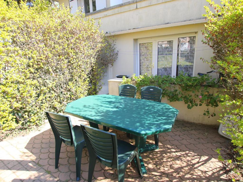 einen grünen Tisch und Stühle auf einer Terrasse in der Unterkunft Appartement Saint-Brevin-les-Pins, 3 pièces, 4 personnes - FR-1-364-43 in Saint-Brevin-les-Pins