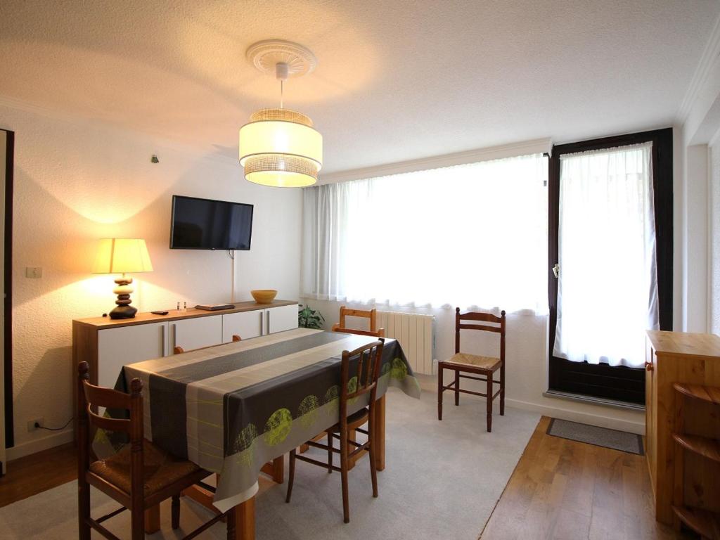 un salon avec une table, des chaises et une télévision dans l'établissement Appartement T3 au Mont-Dore - Balcon, Parking, Proche Centre Ville, 6 Pers, Charges Incluses - FR-1-415-147, à Le Mont-Dore
