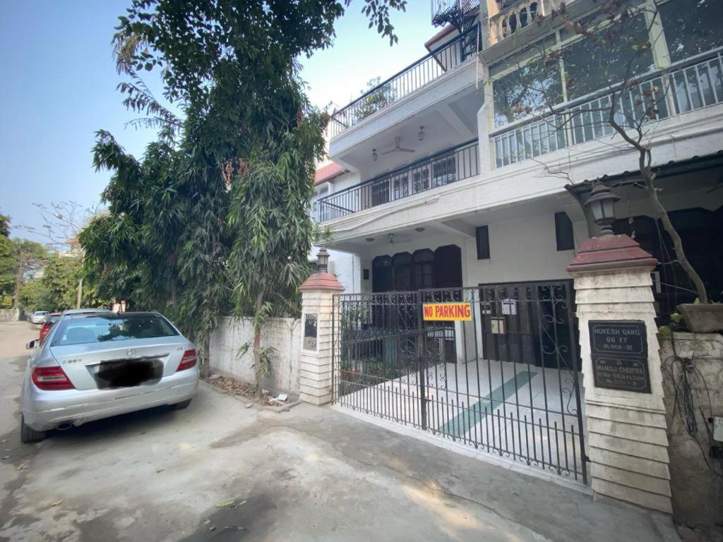 a car parked in front of a white house at Independent Spacious Fully Furnished Room in House in Faridabad