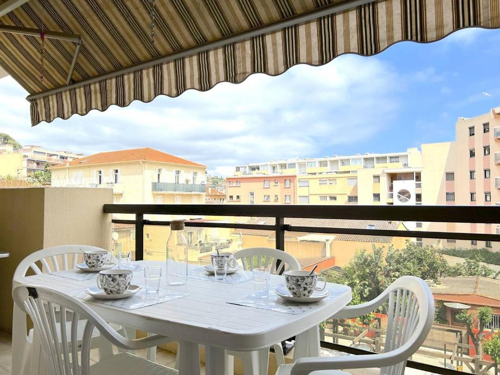 une table blanche et des chaises sur un balcon dans l'établissement Appartement Climatisé 2 Pièces + Coin Nuit, Proche Plage et Commerces, 4 Couchages, Le Lavandou - FR-1-251-829, au Lavandou