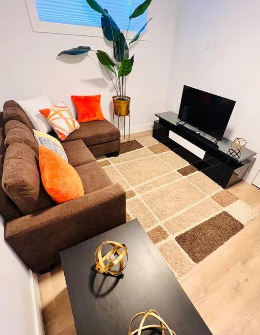 a living room with a couch and a television at B19 Modern Stylish 2bed Basement Suite in Edmonton