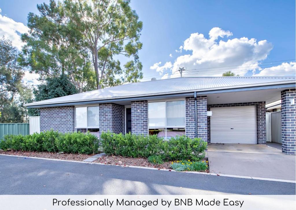 a brick house with a garage at Mason's Lodge - Family Entertainer, Close to Mall in Dubbo