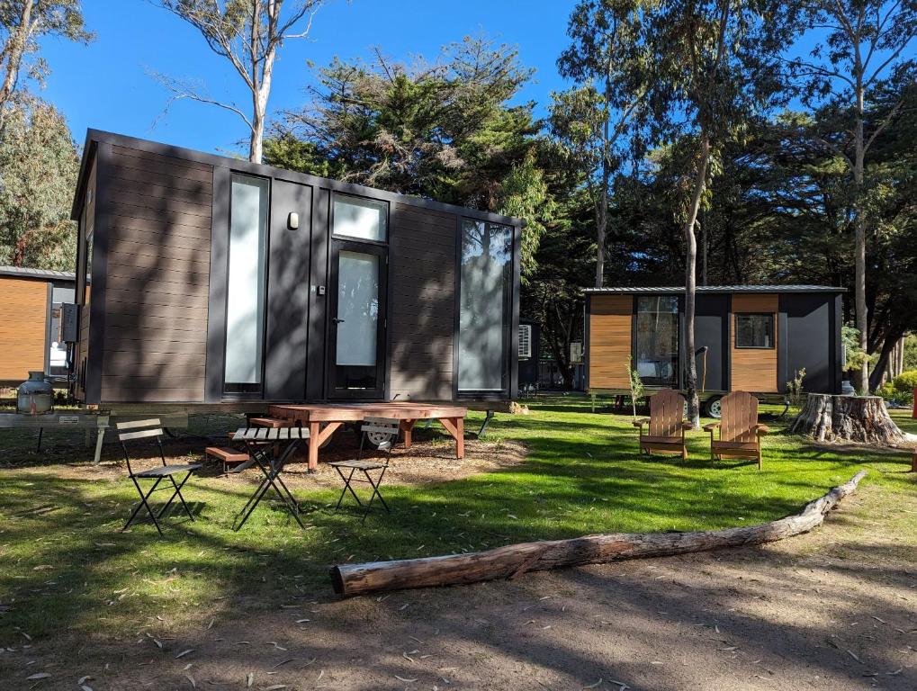 a tiny house with a picnic table and chairs at Tiny House 3 at Grampians Edge in Dadswells Bridge