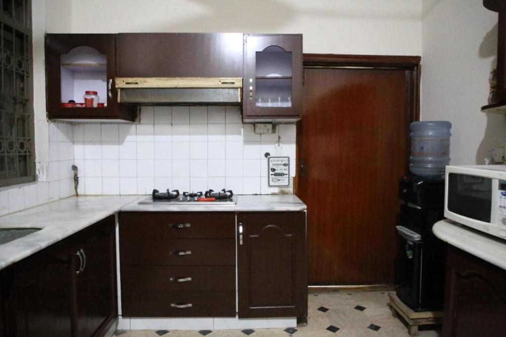 eine Küche mit einer Spüle und einer Mikrowelle in der Unterkunft 6 bedrooms Villa in DHA in Lahore