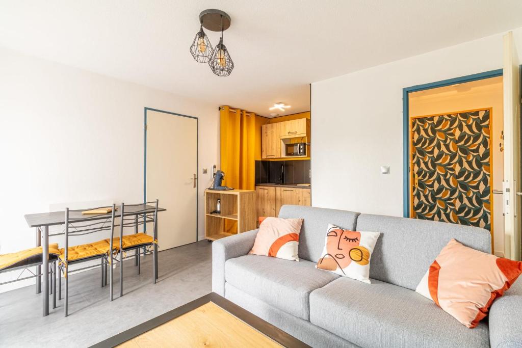 un salon avec un canapé et une table dans l'établissement Cosy apartment with pool, à Toulouse