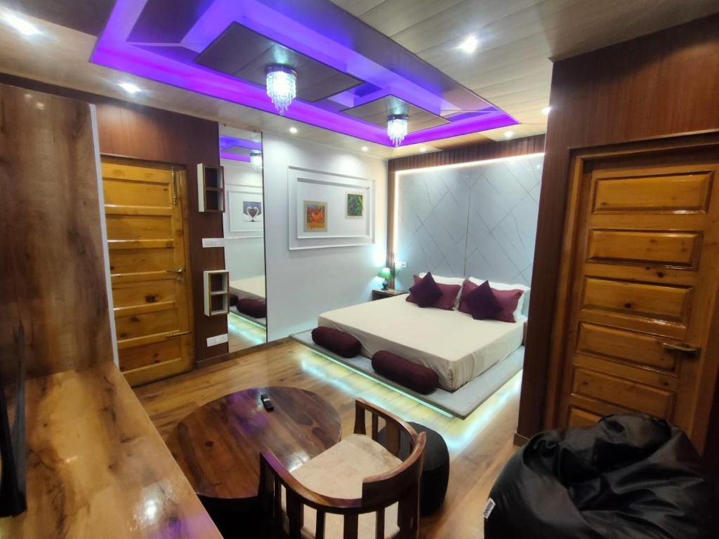 Shimla Abode في شيملا: غرفة نوم بسرير وطاولة واضاءة ارجوانية