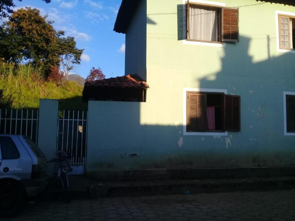 帕薩誇特魯的住宿－Casa Familiar，一座带围栏的白色房子和停在房子旁边的一个停车位