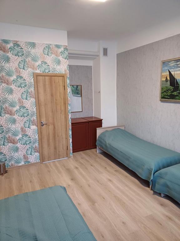 Habitación con 2 camas y puerta. en Green Oaks Private Rooms with Private Shower en Klaipėda