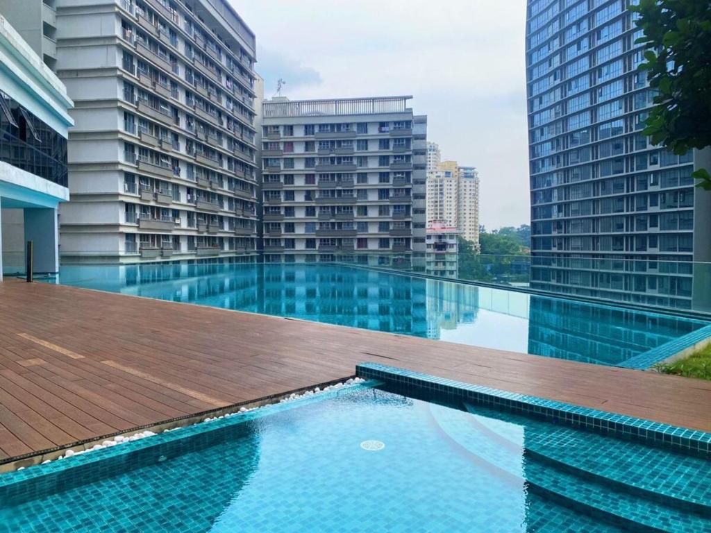 a swimming pool in a building with tall buildings at KL Gateway Premium Residences in Kuala Lumpur