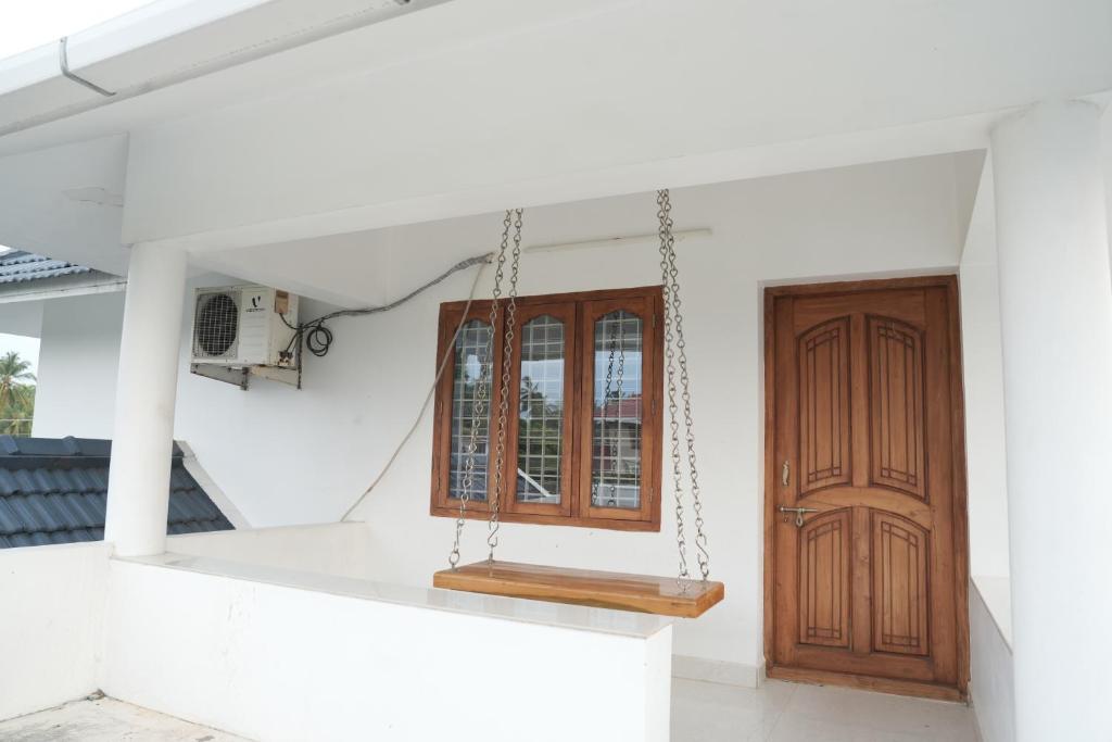 una veranda con altalena e porta di Geetha Ravi Nilayam a Palakkad