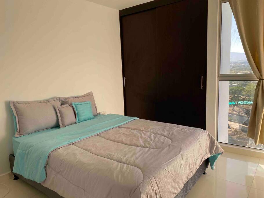 1 dormitorio con 1 cama grande y ventana en Altos del este, apto familiar y acogedor, en Cúcuta