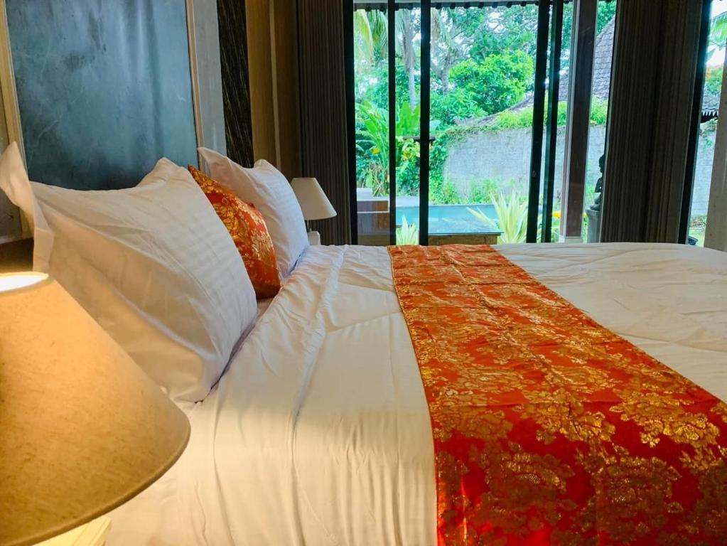 烏布的住宿－麥賀薩別墅，一间卧室配有带白色床单和枕头的床。