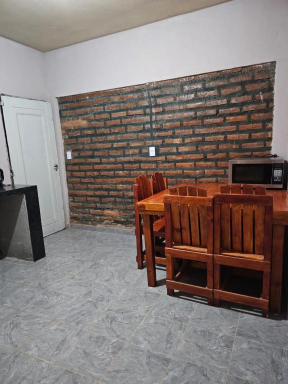 a room with a table and chairs and a brick wall at El gumer in San Fernando del Valle de Catamarca