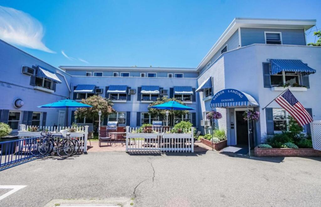 um grande edifício azul com mesas e guarda-sóis em Harbor Landing Resort em Vineyard Haven