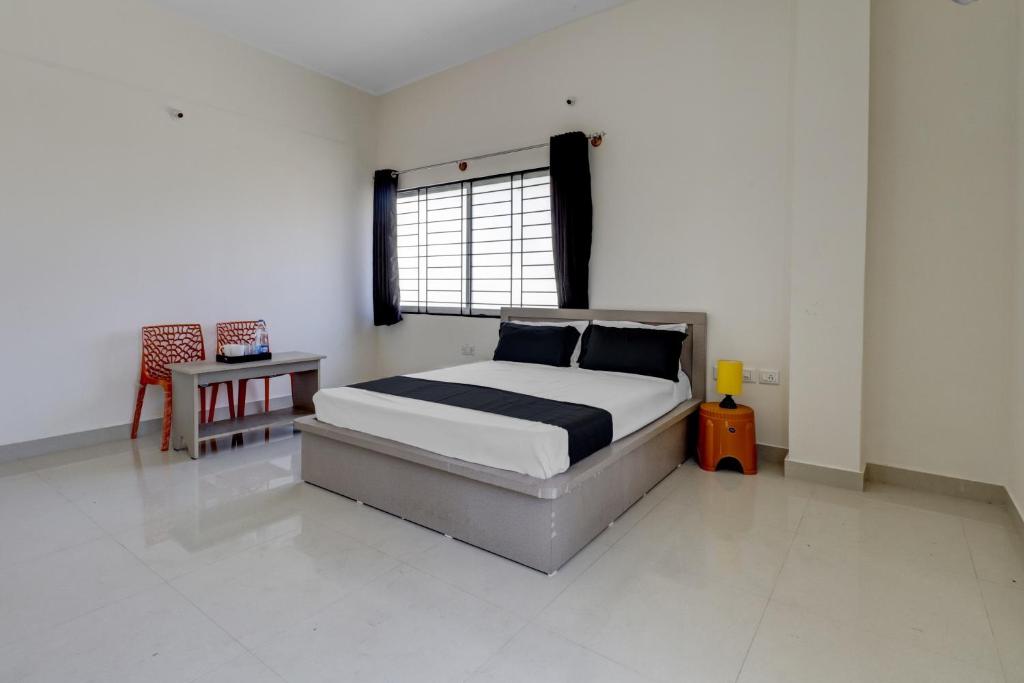 1 dormitorio con cama, mesa y ventana en OYO Power Spirits Boarding and Lodging, en Bangalore