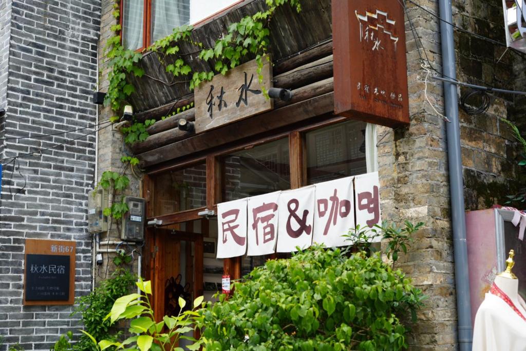a building with a sign on the side of it at Autumn Inn in Yangshuo