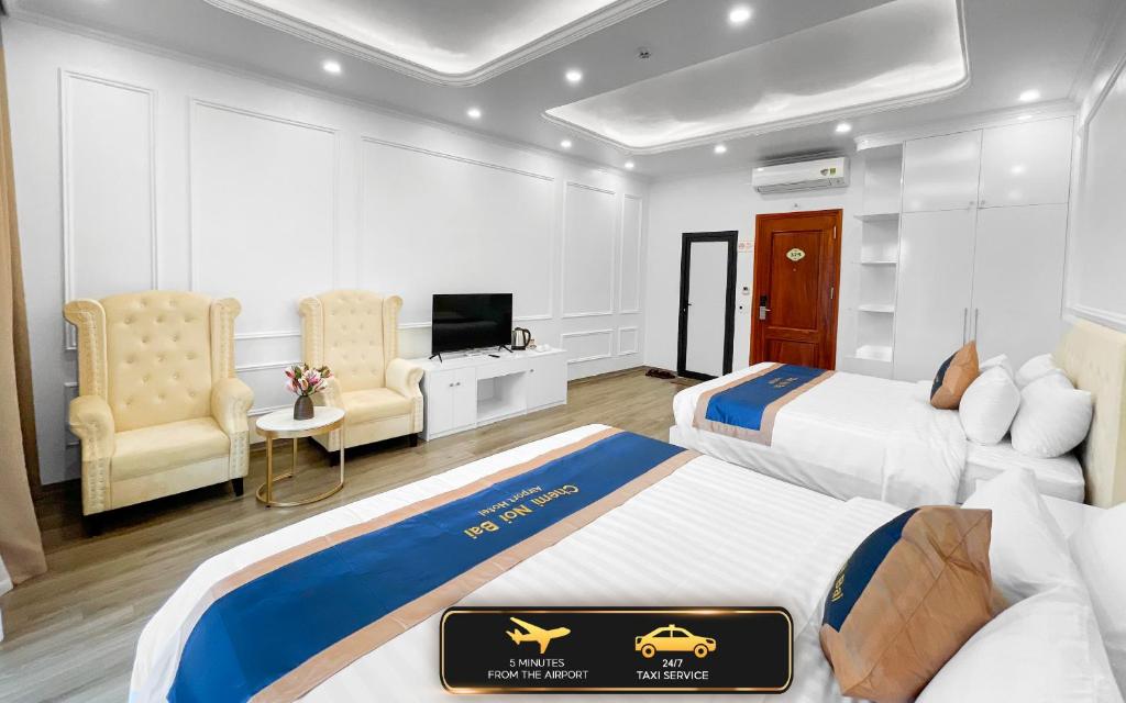um quarto de hotel com duas camas e uma televisão em Chemi Noi Bai Airport Hotel em Hanói