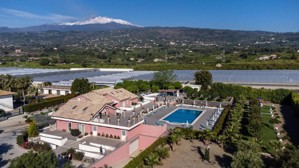 eine Luftansicht eines Hauses mit Pool und Berg in der Unterkunft Dipladenia Garden Country Resort in Mascali