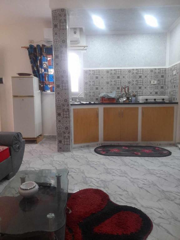 ein Wohnzimmer mit einer Küche und einem Tisch in der Unterkunft Dessine-moi un chameau in Douz