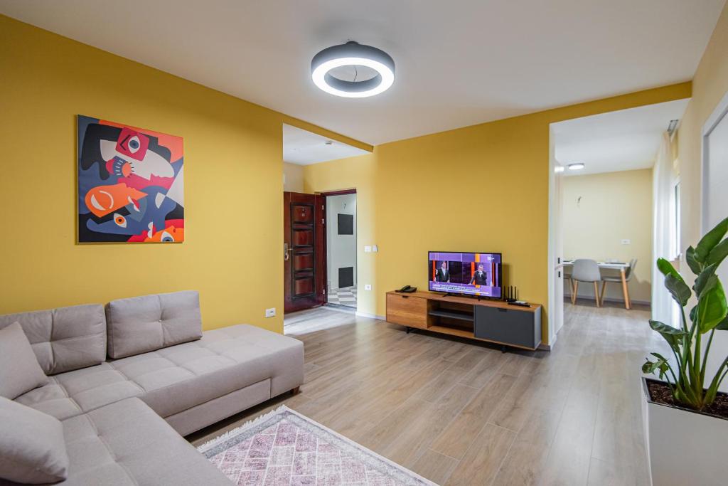 een woonkamer met een bank en een tv bij ApartHotel EDA in Durrës