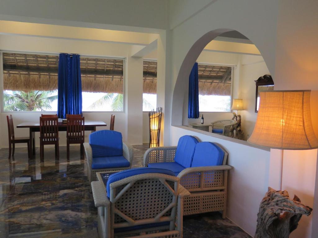 モアルボアルにあるThe Wild Orchid Resort - Moalboalのリビングルーム(青い椅子、テーブル付)