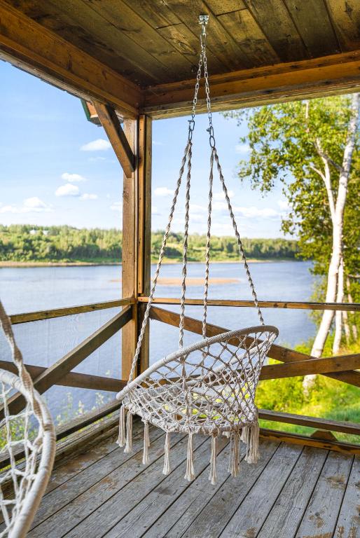 a swing on a porch with a view of the water at Knotty Pines 4 Bedroom with Waterfront Views in Chelmsford