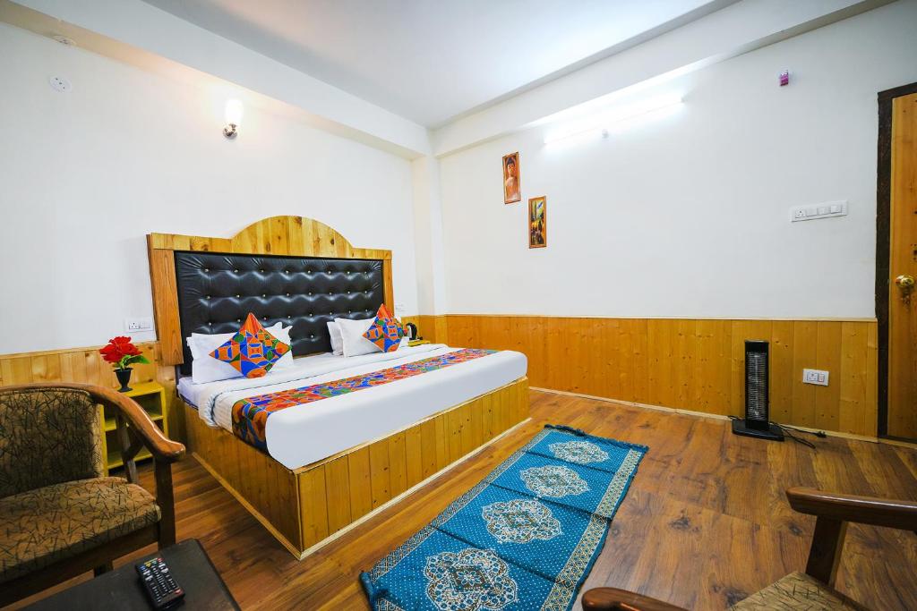 1 dormitorio con 1 cama grande y 1 silla en FabHotel Paradise Guest House en Bashist