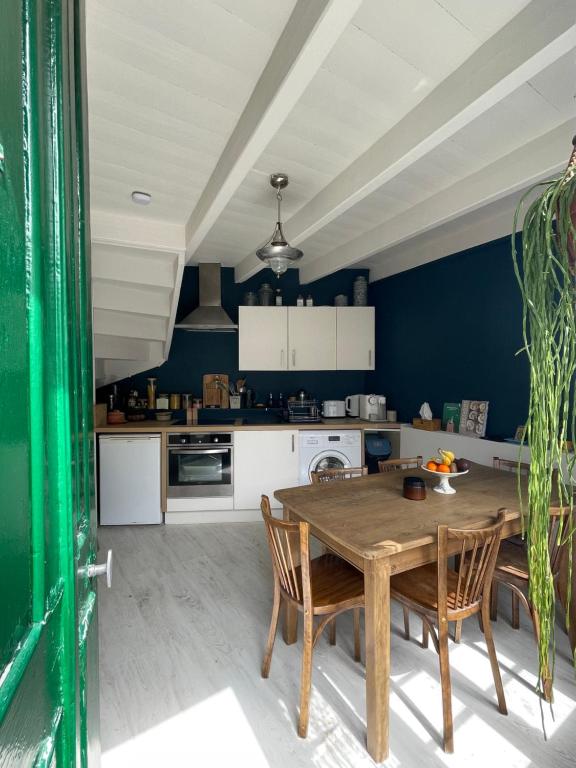 une cuisine avec une table et des chaises en bois dans l'établissement Confiserie de la Fontaine, à Saint-Quay-Portrieux