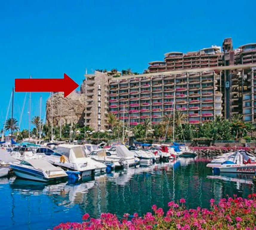 a group of boats docked in a marina with a building at Penthouse 3 Bedroom Sleeps 8 With 270 deg Sea Views in Mogán