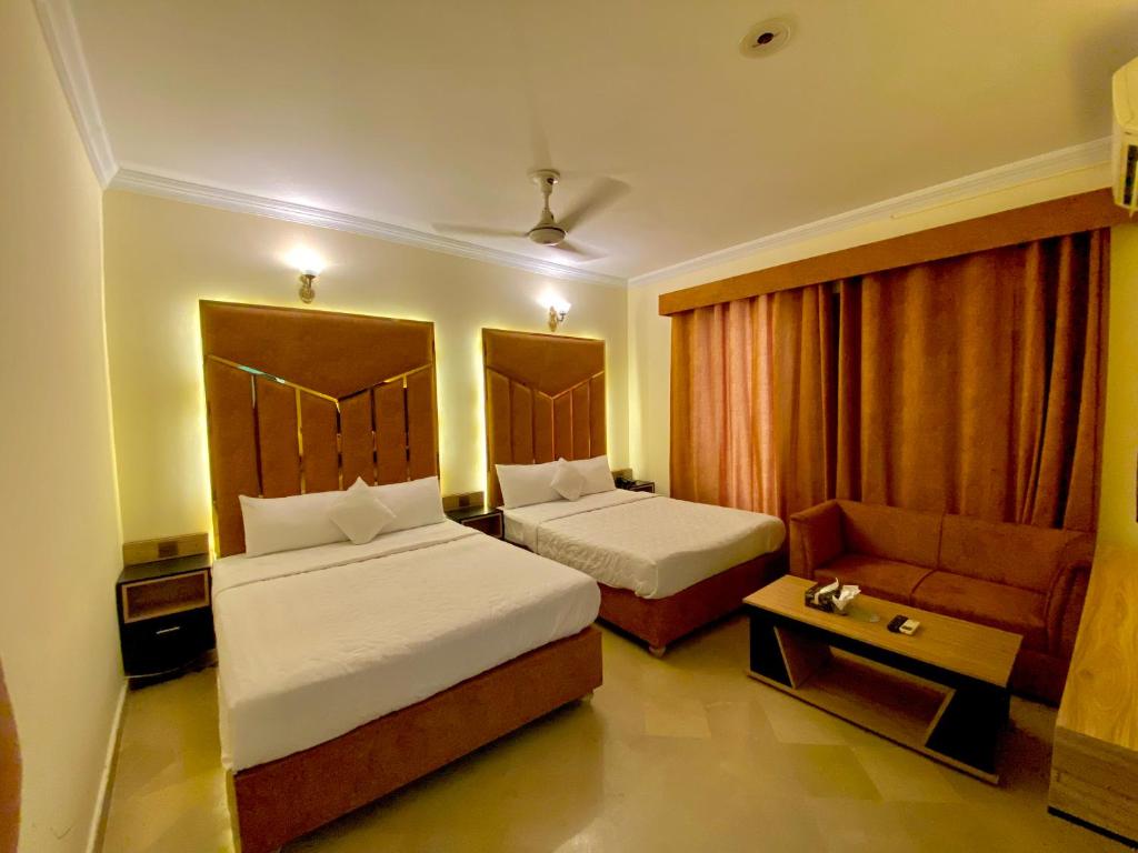 a hotel room with two beds and a couch at Orbit Residency F-7 in Islamabad