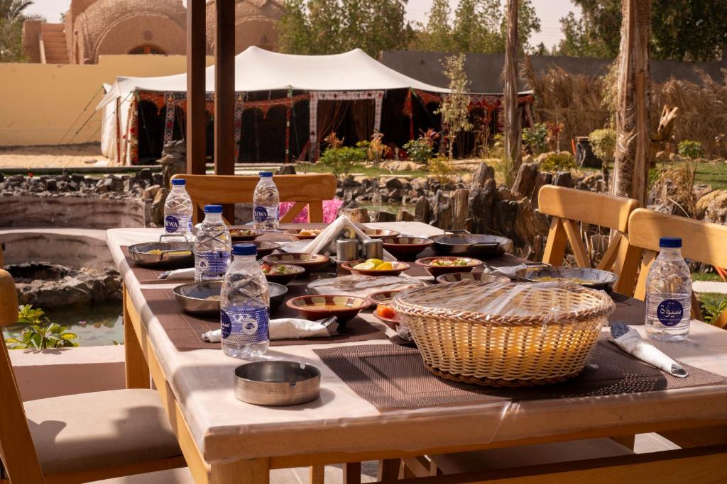 Siwa Sunrise Hotel في سيوة: طاولة عليها زجاجات طعام وماء
