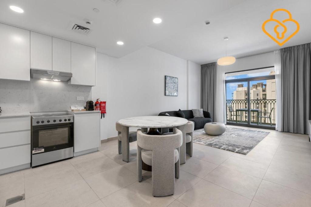 uma cozinha e sala de estar com uma mesa e um sofá em Keysplease 1 BR Apt, Madinat Jumeirah Living em Dubai
