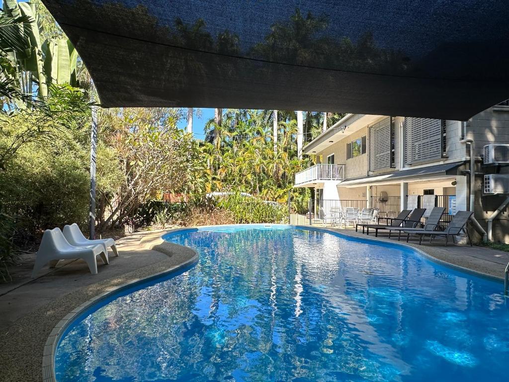 una piscina con 2 sillas blancas junto a un edificio en 4 Bedroom House in Arcadia with huge Pool and Wifi 'Brookehaven' en Arcadia