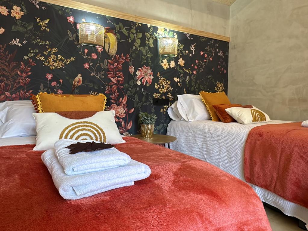 two beds in a room with floral wallpaper at Castaños - Casal do Conde in Dimo