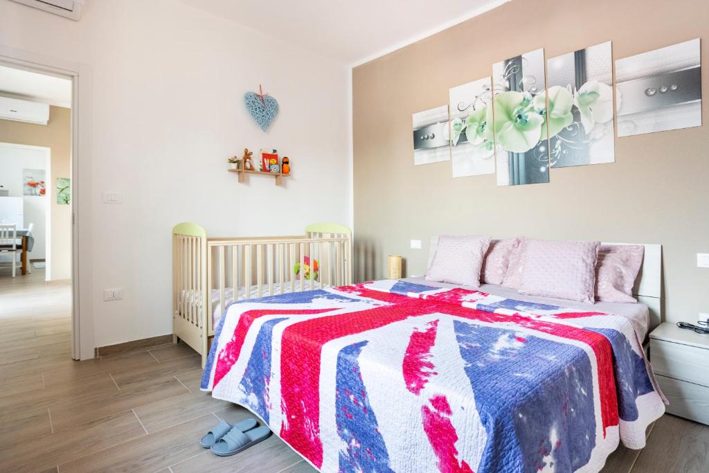 a bedroom with a bed with a red white and blue blanket at Baracca Apartment in Massa Lombarda