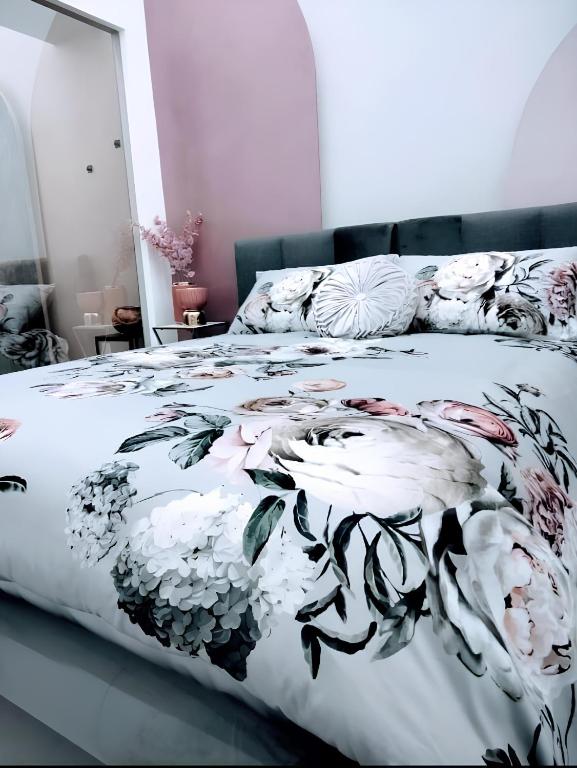 a bedroom with a bed with a floral bedspread at SUITE Corso Roma in Cerignola