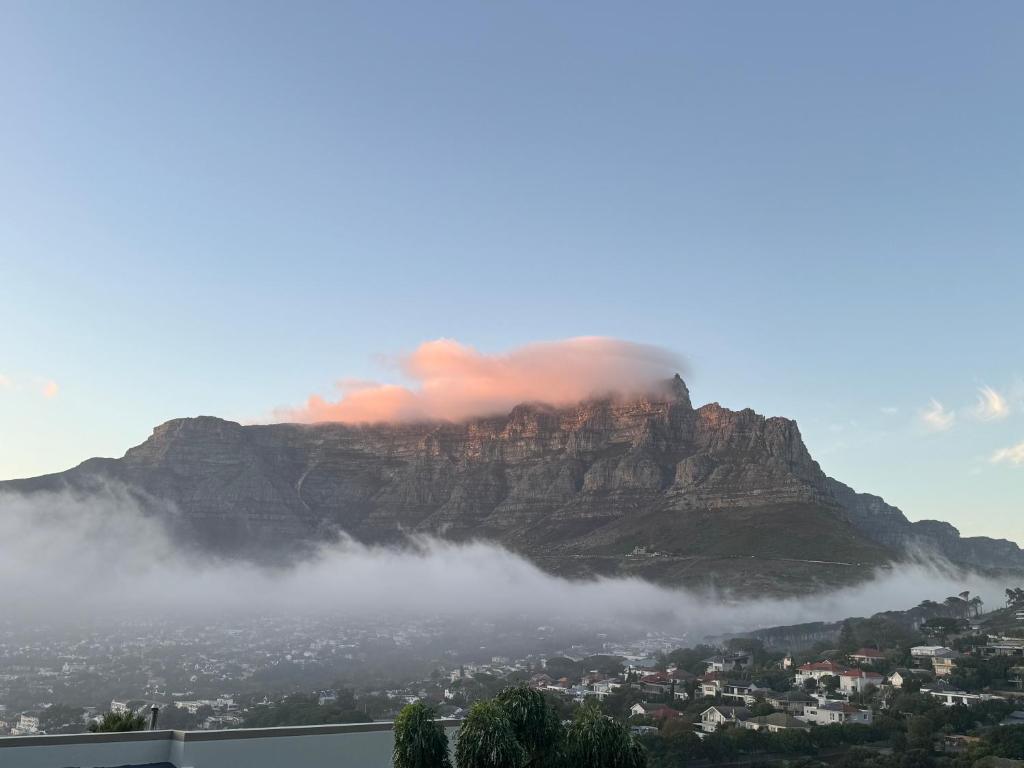 góra zasłonięta chmurami z miastem na pierwszym planie w obiekcie Incredible Cape Town Corner w Kapsztadzie