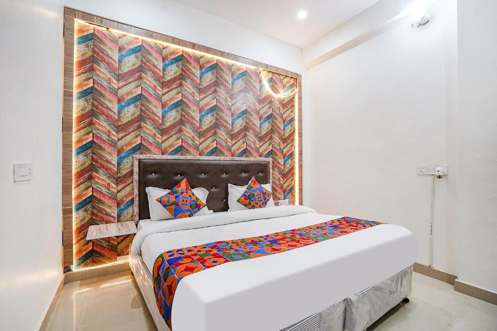 a bedroom with a bed and a colorful wall at FabHotel Siya Bihari in Ayodhya