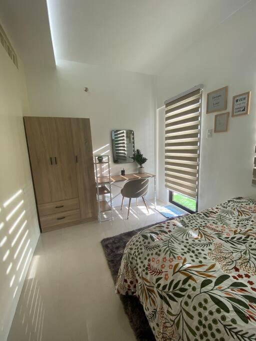 a bedroom with a bed and a table in it at Royal Oceancrest Mactan - Relaxing Sunset View in Lapu Lapu City