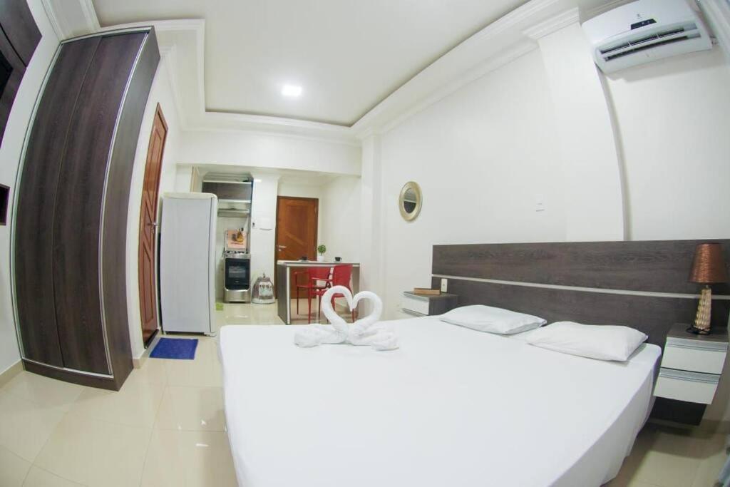 una camera da letto con un grande letto bianco con un cuore sopra di Temporada centro de Manaus, luxo e conforto 703 a Manaus