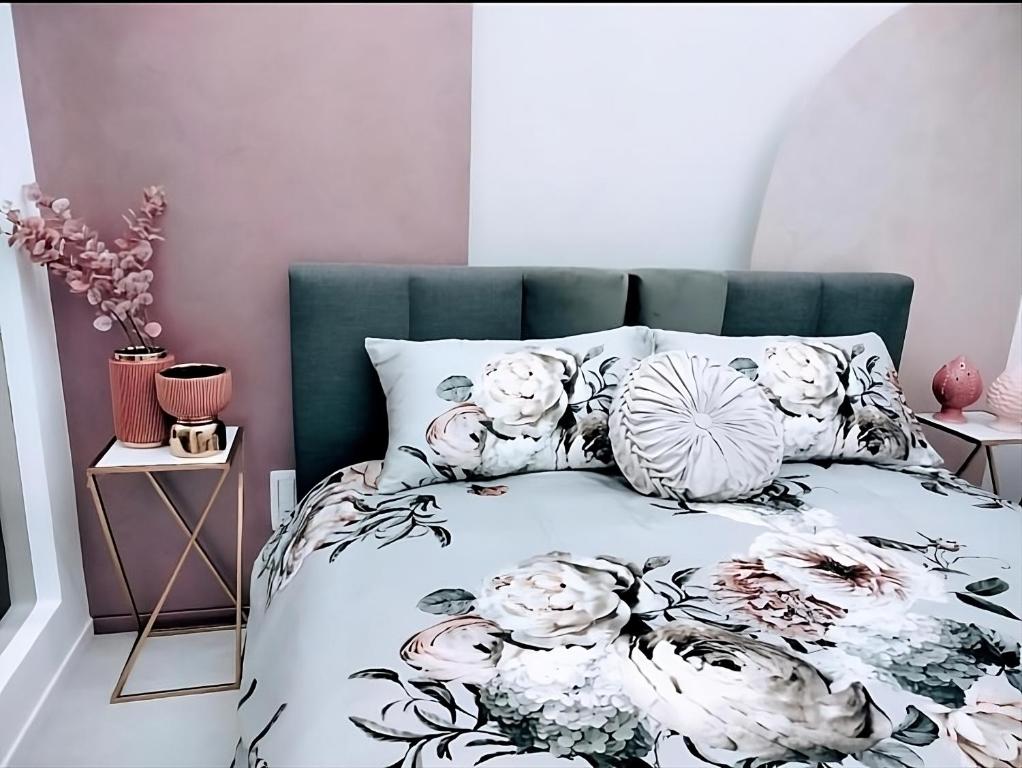 Un dormitorio con una cama con flores. en SUITE Corso Roma, en Cerignola
