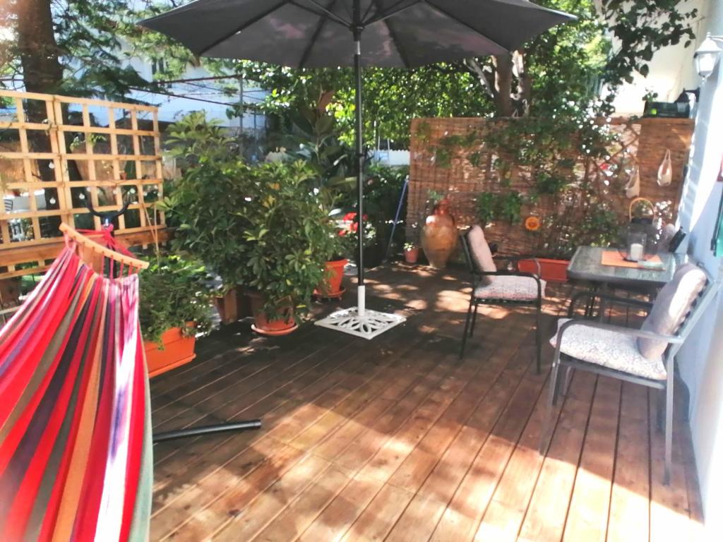 a patio with an umbrella and chairs and a table at Olga's Cozy Nest , apartment in Ano Korakiana. in Áno Korakiána