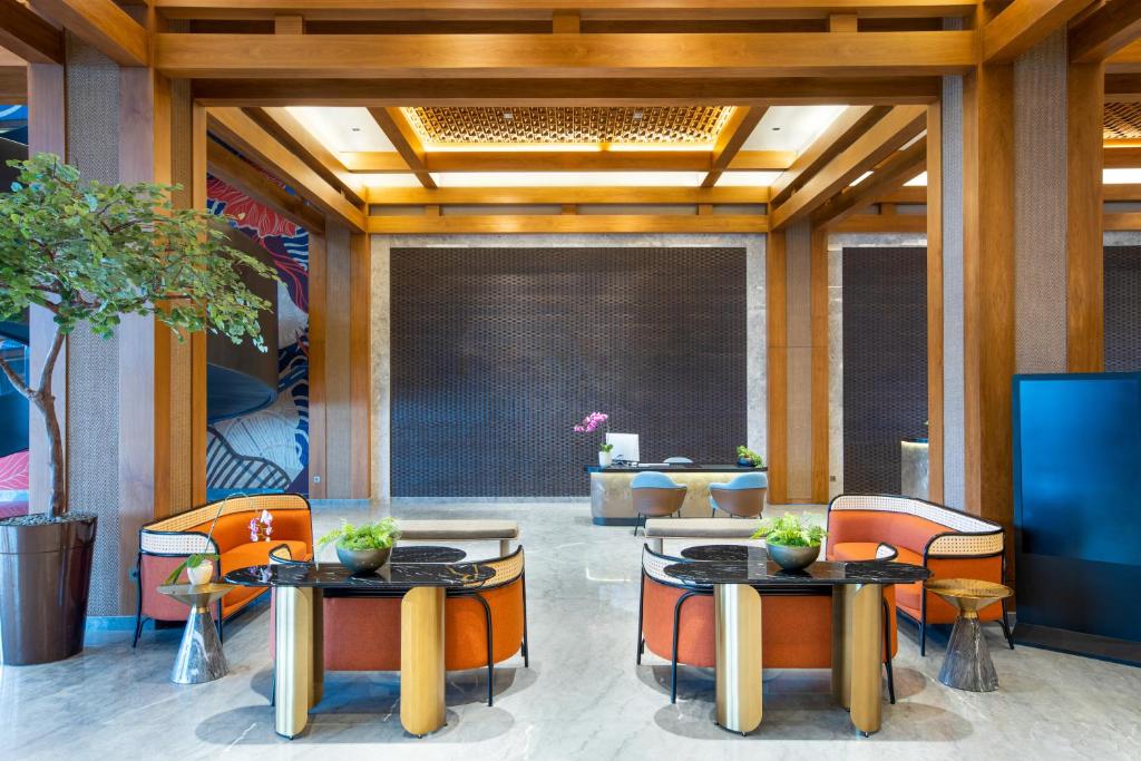 a lobby with two tables and chairs and a tv at MORAZEN Yogyakarta in Temon