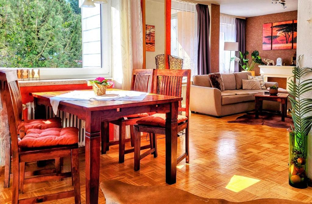een woonkamer met een houten tafel en stoelen bij Komfortwohnung "Domizil Kenia" in Bad Harzburg