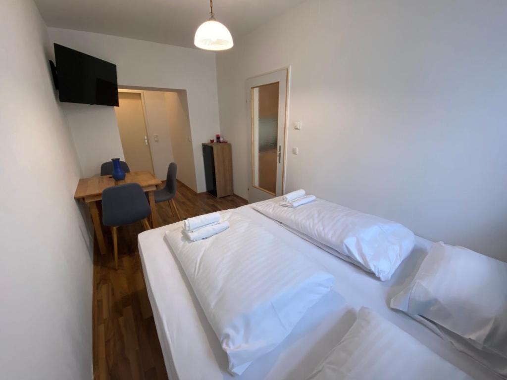 a bedroom with a bed and a table and a desk at Nearby Trainstation Meidling in Vienna