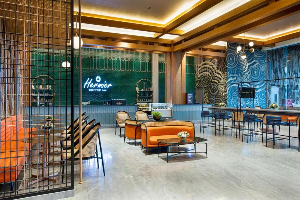 a lobby with chairs and tables and a bar at MORAZEN Yogyakarta in Temon