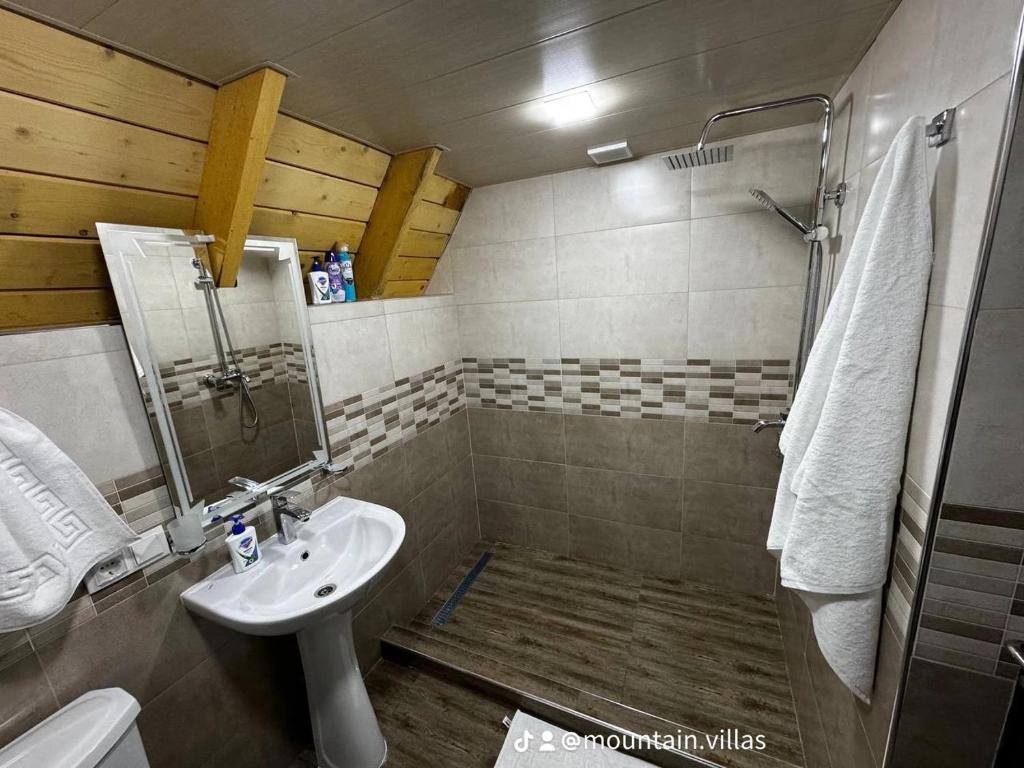 een kleine badkamer met een wastafel en een douche bij The Mountain Villas in Hankavan