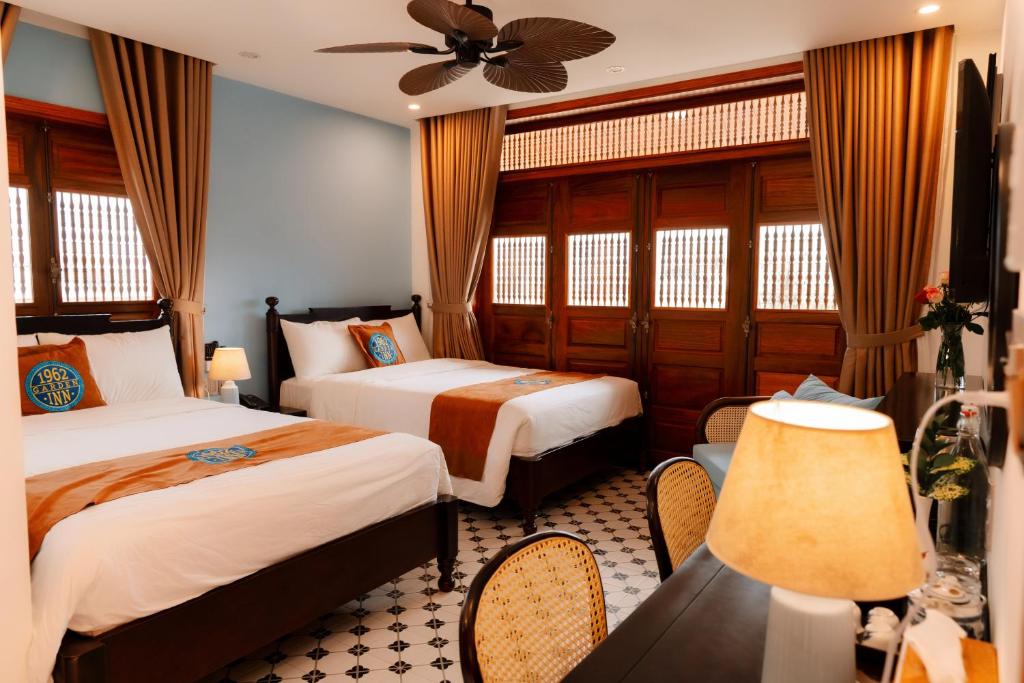 um quarto de hotel com 2 camas e uma ventoinha de tecto em 1962 Garden Inn em Hue
