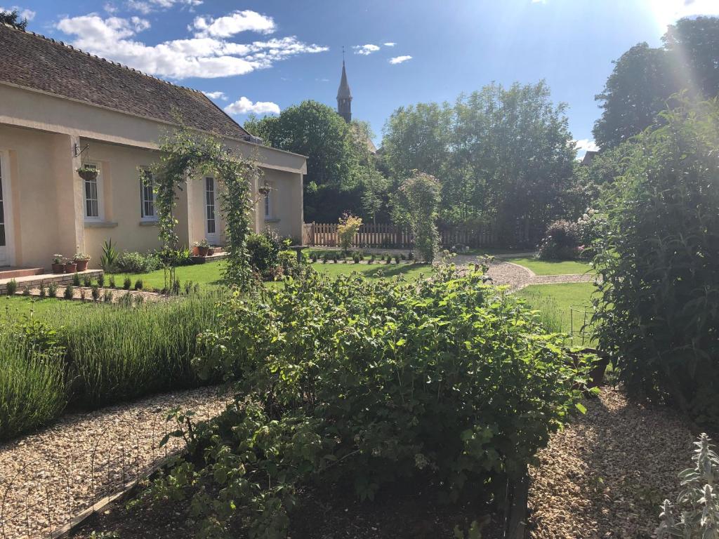 een tuin met een huis en een kerk bij Riverside Lodge in Chablis